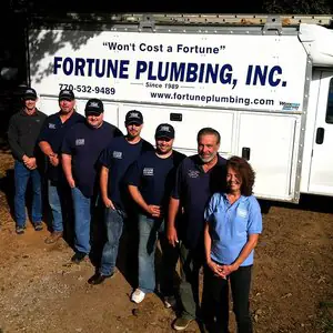 The Fortune Plumbing team in front of a company service van lettered Fortune Plumbing, Inc. Since 1989